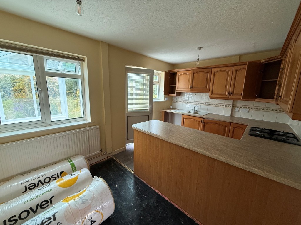 Lot: 114 - THREE-BEDROOM HOUSE FOR IMPROVEMENT AND REPAIR - Fitted Kitchen with dining area and access to the conservatory